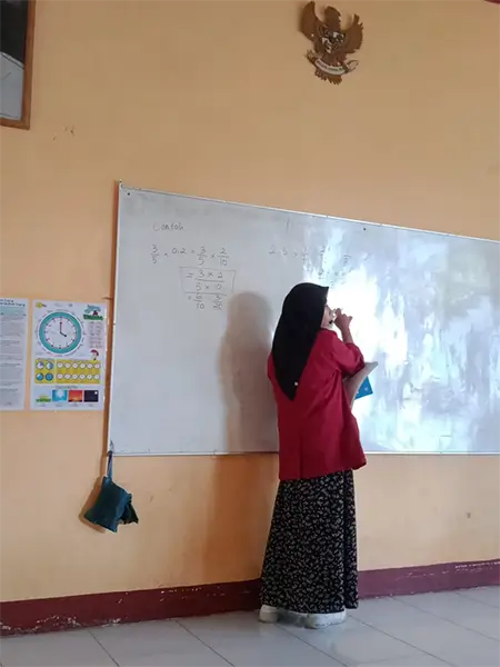 Afni Nurul Sabilah saat membimbing siswa di ruang kelas.