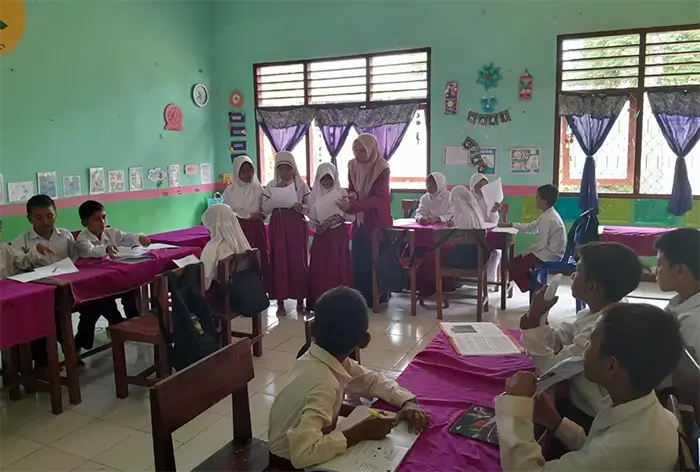 Nur Halizsah Andini sedang membimbing siswa di ruang kelas.