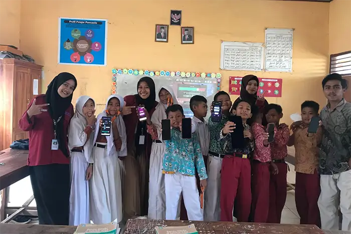 Ines foto dengan murid dan guru saat menjadi fasilitator Program Kampus Mengajar.