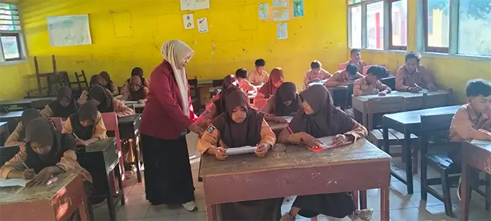 Wulandari Trisnawati saat mendampingi siswa di kelas.