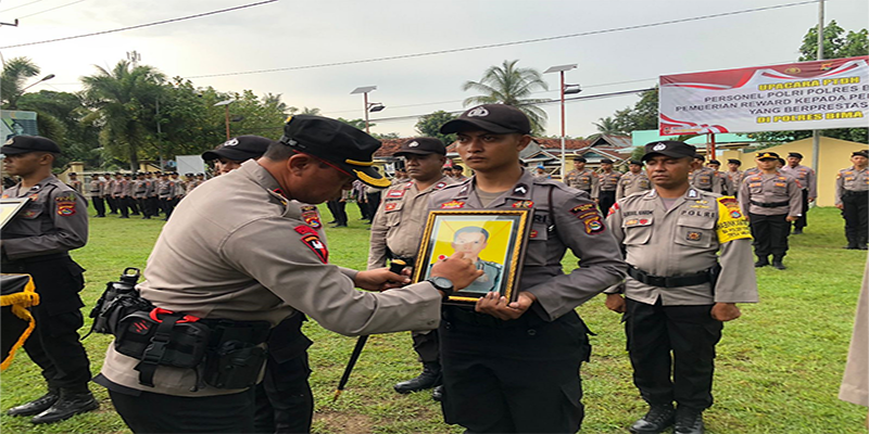 Kapolres Bima AKBP Hariyanto memberi tanda silang di foto anggota Polres Bima yang melanggar disiplin dan kode etik menandai pemberhentian tiga Bintara Polres Bima dari dinas Polri, Rabu (1/2/2023).