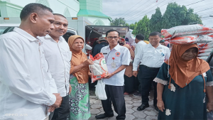 Kepala Diskoperindag Kota Bima, A Haris menyerahkan beras murah saat operasi pasar yang digelar TPID Kota Bima bersama Perum Bulog di Kecamatan Raba, Rabu (8/3/2023).