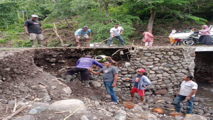 Sejumlah warga bergotong royong membenahi sisi samping ruas jembatan (plat duiker) yang ambles di Desa Mawu Kecamatan Ambalawi Kabupaten Bima. Material untuk membenahi jembatan sebagaian besar bersumber dari bantuan pribadi anggota DPRD, Ma’rif Takwa.