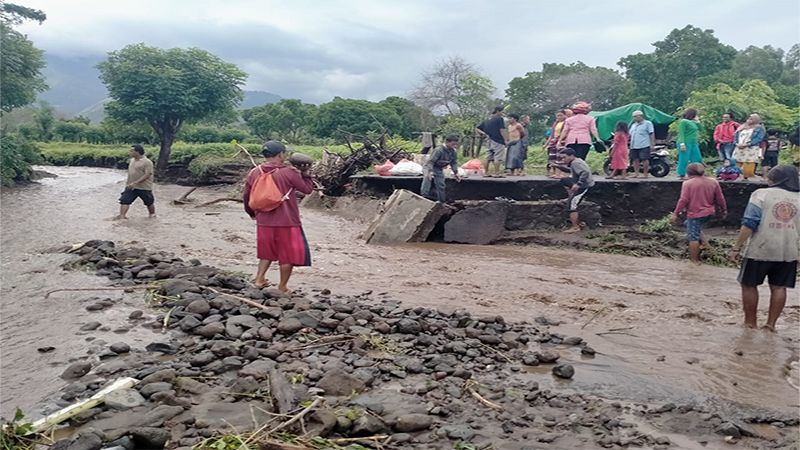 Sejumlah warga melihat kondisi jalan putus akibat diterjang banjir di Desa Kawinda Toi Kecamatan Tambora Kabupaten Bima, Nusa Tenggara Barat, Kamis (2/3/2023).  