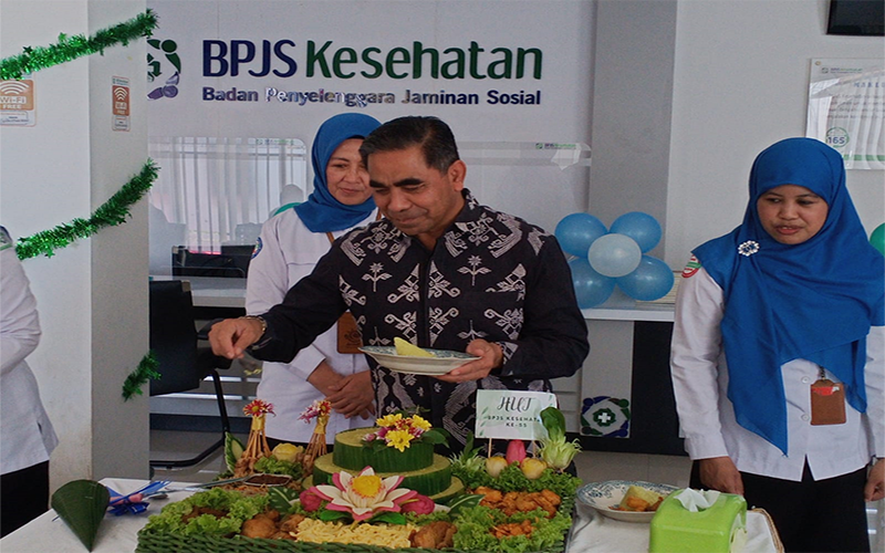 Plh Sekda Kota Bima, H Fakhrurazy didampingi Kepala BPJS Kesehatan Cabang Bima, Tati Haryani Denawati memotong tumpeng pada puncak upacara HUT ke-55 BPJS Kesehatan yang berlangsung di kantor BPJS Kesehatan Cabang Bima di Jalan Soekarno-Hatta Kelurahan Penaraga Kota Bima, Sabtu (15/7/2023). Foto Sukriyadin/ Berita11.com.