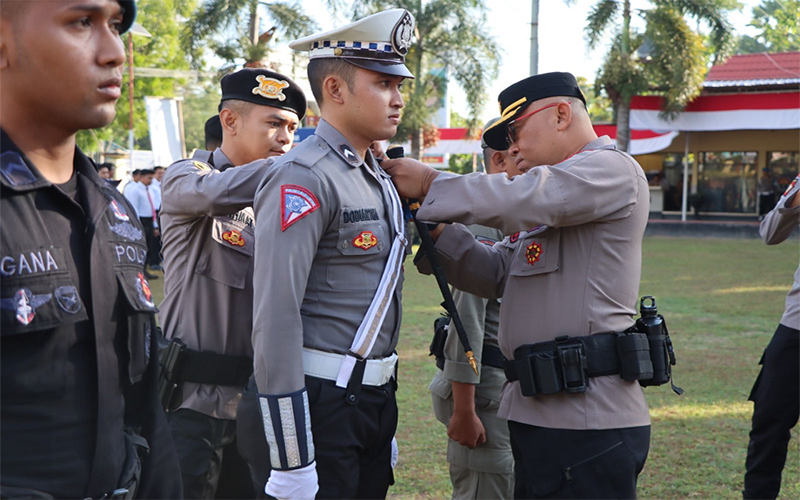 Kapolres Bima AKBP Hariyanto memasang tanda pita kepada anggota Satuan Lalu Lintas pelaksana Operasi Patuh Rinjani 2023 saat apel di Markas Polres Bima, Senin (10/7/2023).