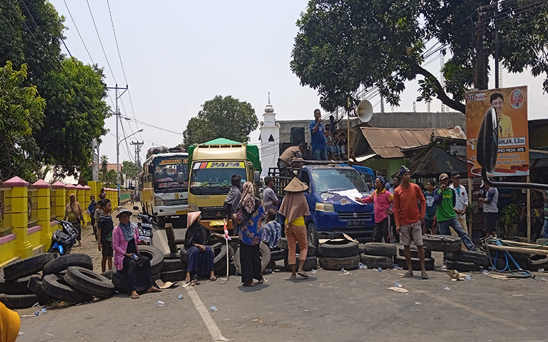 Massa Aliansi Masyarakat Pencari Keadilan Desa Rasabou saat menggelar aksi menutup ruas jalan negara Lintas Bima-Sumbawa di persimpangan di depan SDN 3 Sila Kecamatan Bolo Kabupaten Bima, Rabu (25/10/2023) siang.  