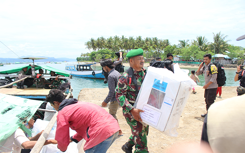 Anggota Posramil Langgudu Kabupaten Bima membantu memasukan logistic pemilu ke perahu yang akan digunakan membawa logistic ke desa pesisir terpencil di Kecamatan Langgudu Kabupaten Bima, Selasa (13/2/2024) pagi.