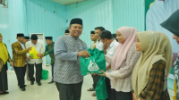 Sekda Kota Bima, H Muhtar menyerahkan sembako saat menghadiri Safari Ramadan Kepala Kemnag NTB di Convention Hall Paruga Nae Kota Bima,