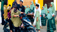 Guru pembimbing dan santri-santriwati Rumah Hafidz Al Quran berbasis perpustakaan saat membagikan takjil kepada pengendara yang melintas di depan kantor Desa Sangia Kecamatan Sape Kabupaten Bima, Senin (1/4/2024).