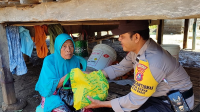 Bhabinkamtibmas Desa Mapin Kebak Kecamatan Alas Barat KSB Aipda Burhanuddin saat memberikan sembako kepada warga lanjut usia di desa binaanya.
