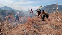 Personel Kepolisian Sektor (Polsek) Bolo dan Polsek Donggo bahu membahu memadamkan kebakaran lahan di Desa Mbawa, perbatasan Kecamatan Donggo dan Kecamatan Bolo, Senin (10/6/2024) lalu.
