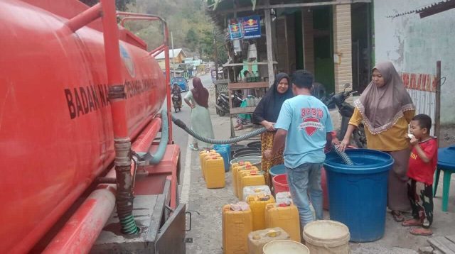 Petugas BPBD Kabupaten Bima menyalurkan bantuan air bersih untuk ratusan kepala keluarga yang mengalami krisis air bersih akibat dampak bencana kekeringan dan cuaca panas (El Nino) di Kabupaten Bima.
