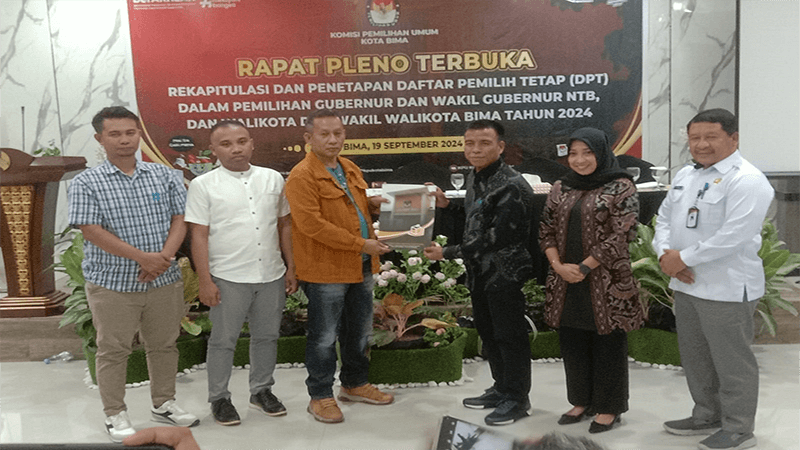 Ketua KPU Kota Bima, Suaeb didampingi sejumlah komisioner KPU Kota Bima menyerahkan Salinan berita acara penetapan DPT Kota Bima kepada penghubung calon kepala daerah dan calon wakil kepala daerah usai rapat pelno terbuka di Rumah Makan Dining Kota Bima, Kamis (19/9/2024) lalu. Foto MR/ Berita11.com.
