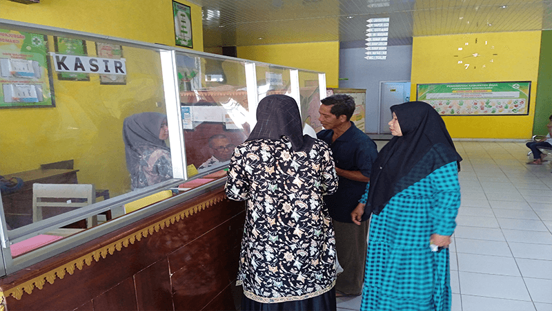 Syamsuddin dan sejumlah pasien saat mengantri untuk mendapat pelayanan di fasilitas kesehatan tingkat pertama di Kabupaten Bima.