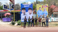 Staf KPU Kabupaten Bima foto di depan baliho yang difasilitasi oleh KPU.