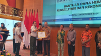 Sekda Kabupaten Bima, Adel Linggi Ardi saat menerima anggaran rekonstruksi pasca bencana Rp14,4 miliar dari Pemerintah Pusat di Gedung Graha BNPB Jakarta, Selasa (12/11/2024).