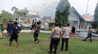 Konsentrasi warga dan aparat keamanan saat berupaya memadamkan api yang melahap kantor Camat Woja Kabupaten Dompu, Minggu (24/11/2024) pagi.