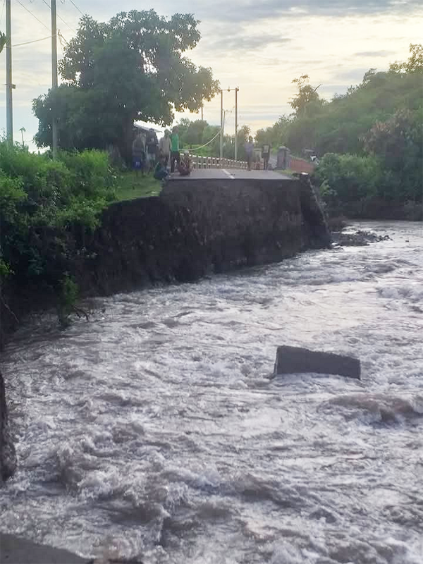 Kondisi jalan ambrol di sekitar jembatan di Desa Sampungu Kecamatan Soromandi, Kabupaten Bima, Nusa Tenggara Barat, Minggu (29/12/2024). Akibatnya mobilisasi warga di desa ini menghubungkan sejumlah wilayah lain di Kabupaten Bima terganggu.