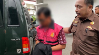 Tersangka dugaan korupsi dana BOS SMAN 1 Woha Kabupaten Bima saat hendak diangkut pihak Kejari Bima, Senin (9/12/2024). Terangka berinisial HJ ini akan menjalani penahanan 20 hari mendatang di Rutan Raba Bima.