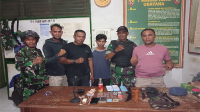 Terduga pengedar narkoba(tengah) yang tangkap tangan oleh aparat TNI disaksikan aparatur pemerintah desa. Terduga kemudian diserahkan kepada aparat kepolisian untuk diproses.