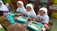 Sejumlah siswa sekolah dasar di Kecamatan Asakota Kota Bima tampak Bahagia menikmati MBG yang didistribusikan mitra BGN di Kota Bima, Senin (17/2/2025).