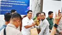 Perwakilan NC untuk Prokohesi Kota Bima, Julhaedin menyerahkan bingkisan kepada stakeholder yang menghadiri peluncuran program untuk menguatkan ketahanan masyarakat dan mantan napi terorisme (napiter) dalam mencegah ektremisme berekerasan dan mempromosikan kohesi sosial di Kota Bima, Selasa (15/4/2025).