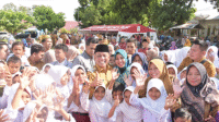Bupati Bima, Ady Mahyudi didampingi Ketua TP PKK Kabupaten Bima foto bersama dengan jubelan siswa di sela peluncuran program Selasa Menyapa sekaligus peringatan Harkitnas di lapangan Desa Rato Kecamatan Lambu Kabupaten Bima, Selasa (20/5/2025).