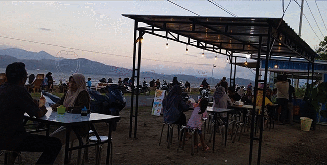 Sejumlah pengunjung tampak santai di lapak mie ayam di Desa Lewintana Kecamatan Soromandi Kabupaten Bima menjelang magrib, Minggu (18/5/2025). Tempat ini menjadi salah satu favorit masyarakat di wilayah Kabupaten Bima untuk menimakti pemandangan Teluk Bima.