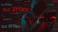 Denial of service or DDoS attack concept with faceless hooded male person using tablet computer, low key red and blue lit image and digital glitch effect.