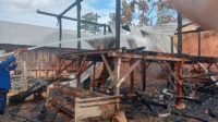 Personil Damkarmat mendinginkan sisa-sisa api di puing-puing rumah korban yang terbakar di Desa Woro Kecamatan Madapangga Kabupaten Bima, Selasa (19/6/2025) pagi.