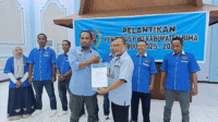 Ketua PWI NTB, H Hasarudin menyerahkan SK pengurus kepada Ketua PWI Kabupaten Bima, Firmansyah di sela-sela pelantikan pengurus PWI Kabupaten Bima di Aula LPP RRI Mataram, Jumat, 1 Agustus 2025.