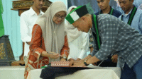 Pj Sekda Kota Bima Hj Mariamah bersama Ketua HMI MPO Cabang Bima menandatangani nota kesepahaman di sela pelantikan pengurus HMI MPO Cabang Bima periode 2025-2026 di Convention Hall Paruga Na'e, Sabtu (20/9/2025).