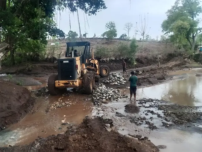 Petugas UPTD Balai Pemeliharaan Jalan Provinsi Wilayah Pulau Sumbawa Bagian Timur sedang meratakan material tanah yang digunakan sebagai jalan darurat sekitar jembatan So Nampa Kecamatan Soromandi yang sedang dibenahi.