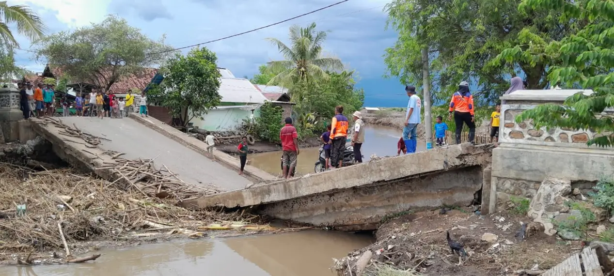 Kondisi jembatan pengubung di Dusun Jala Desa Nggembe Kecamatan Bolo Kabupaten Bima yang ambles setelah diterjang banjir. Sejumlah petugas BPBD Kabupaten Bima melakukan pendataan dampak bencana alam, Minggu (9/11/2025).