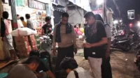 Personil Polsek Bolo saat memeriksa dan menggeledah barang bukti yang dikantungi oleh terduga pengedar obat terlarang, Tramadol dan Trihexyphenidyl di depan toko sekitar Cabang Donggo Kecamatan Bolo, Minggu (23/11/2025) malam.