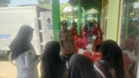 Personil Polsek Bolo saat memantau distribusi MBG untuk siswa saat libur sekolah di MIN Sila Kecamatan Bolo Kabupaten Bima, Senin (23/12/2025).