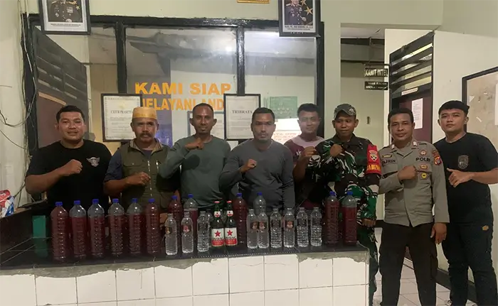 Kapolsek Bolo, AKP Nurdin dan anggota bersama barang bukti puluhan botol miras yang berhasil disita dalam Operasi Lilin Rinjani 2025 yang digelar pada Jumat (26/12/2025) malam.
