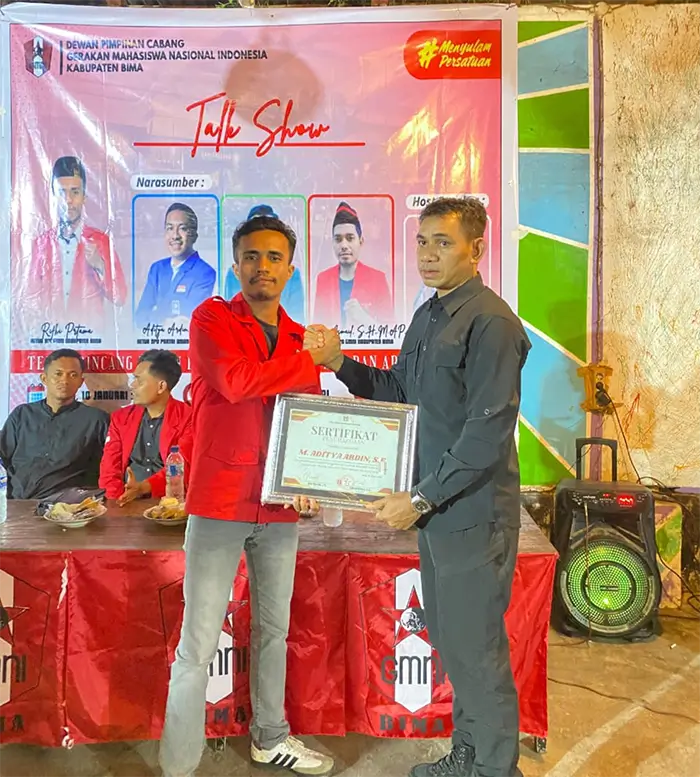 Ketua DPC GMNI Kabupaten Bima, Rifki Pratama menyerahkan piagam kepada narasumber talk show yang juga politisi PAN sekaligus mantan Ketua HMI Cabang Bima, M. Jafar.