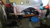 Warga Desa Lewintana Kecamatan Soromandi Kabupaten Bima membersihkan sisa lumpur setelah rumah mereka direndam banjir, Jumat (6/2/2026) malam.