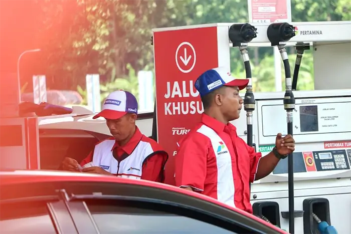 Petugas SPBU melayani konsumen.