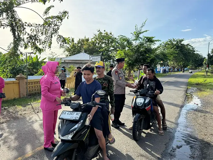 Kapolsek Pekat IPTU Jubaidin bersama Ketua Bhayangkari Ranting Pekat, Anggraini Ningsih Jubaidin membagikan takjil gratis kepada pengendara yang melintas, Kamis (12/3/2026).