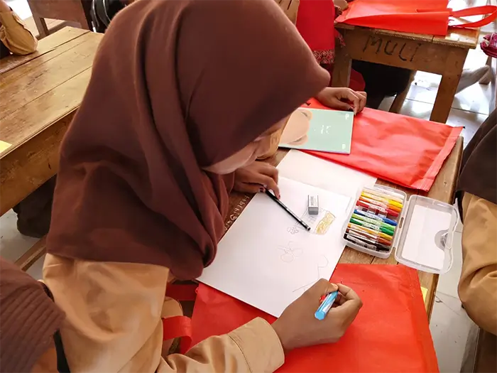 Nabila Alisa Putri berupaya menyelesaikan gambar di tengah keterbatasannya melihat.