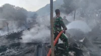 Babinsa Lido Kecamatan Belo membantu mendinginkan sisa kebakaran belasan rumah yang dipicu aksi kakak hendak membakar adik kandungnya.