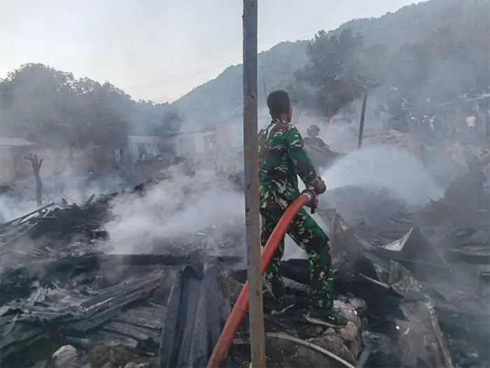 Babinsa Lido Kecamatan Belo membantu mendinginkan sisa kebakaran belasan rumah yang dipicu aksi kakak hendak membakar adik kandungnya.