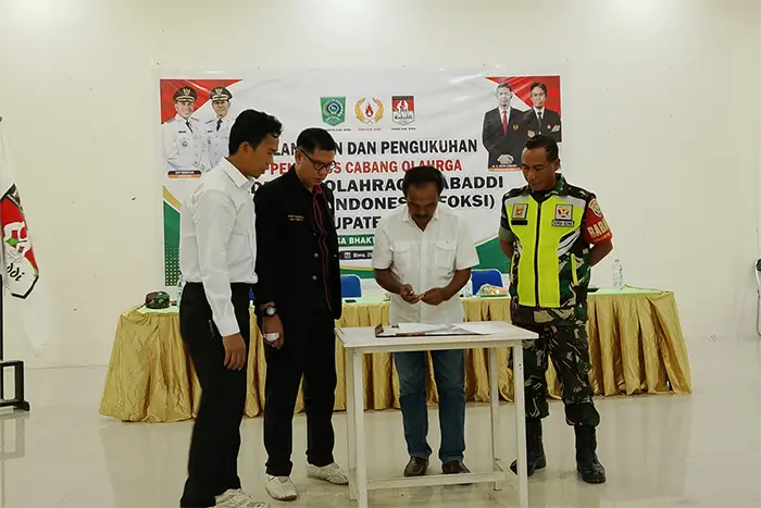 Ketua KONI Kabupaten Bima, Nurdin Amin menandatangani berita acara pelantikan pengurus FOKSI Kabupaten Bima, Kamis (25/6/2026).