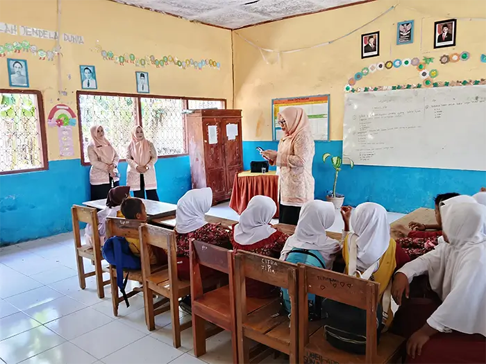 Ketua DWP Kabupaten Bima, Fitriani Adel Linggi Ardi membacakan kisah Nabi Yusuf saat mengunjungi SDN Lewintan Kecamatan Soromandi, salah satu SD sasaran Program Sekolah Aman yang dilaksanakan Yayasan YISA Ambalawi Mbojo dan YAPPIKA ActionAid, Rabu (15/7/2026).