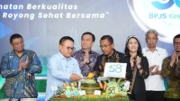 Direktur Utama BPJS Kesehatan, Prihati Pujowaskito dan Kepala Staf Kepresidenan RI, Dudung Abdurachman memotong tumpeng dalam Sarasehan HUT ke-58 BPJS Kesehatan di Kantor Pusat BPJS Kesehatan, Rabu (15/07/2026).
