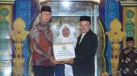 Wakil Bupati Bima, H. Irfan Zubaidy, menyerahkan bantuan di sela membuka Musabaqah Tilawatil Qur’an (MTQ) ke-20 tingkat Kecamatan Soromandi di Desa Lewintana Kecamatan Soromandi, Sabtu (8/8/2026).