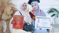 Eri Suryaningsih dan mama tercinta mengabadikan momen usai mengikuti wisuda XXII di STKIP Taman Siswa Bima, Sabtu (26/9/2026).